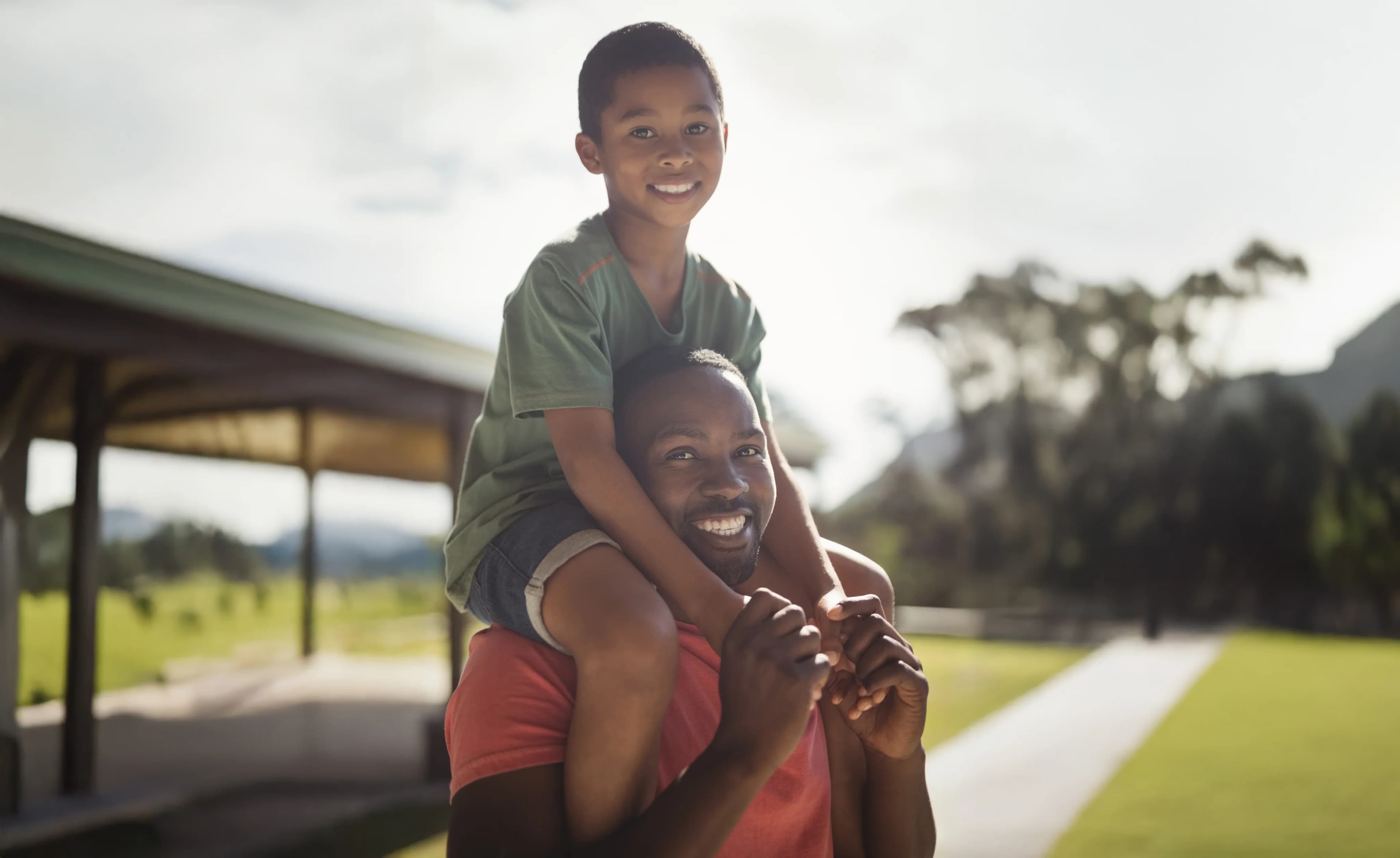 Pai feliz carregando filho nos ombros
